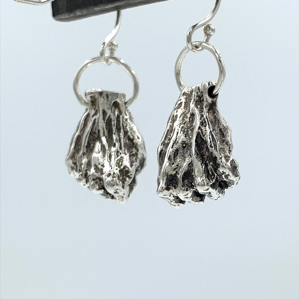 Resilience, Resistance, Power! I love to take elements from my work and make them into wearable art, each one hand made.  Hands in Fists  earrings. Sterling Silver - Holly Wilson