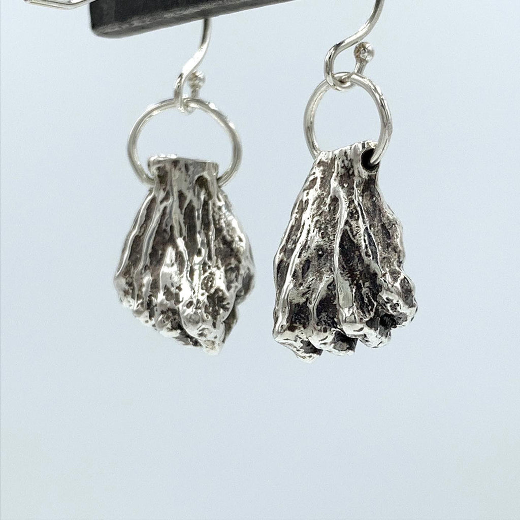 Resilience, Resistance, Power! I love to take elements from my work and make them into wearable art, each one hand made.  Hands in Fists  earrings. Sterling Silver - Holly Wilson